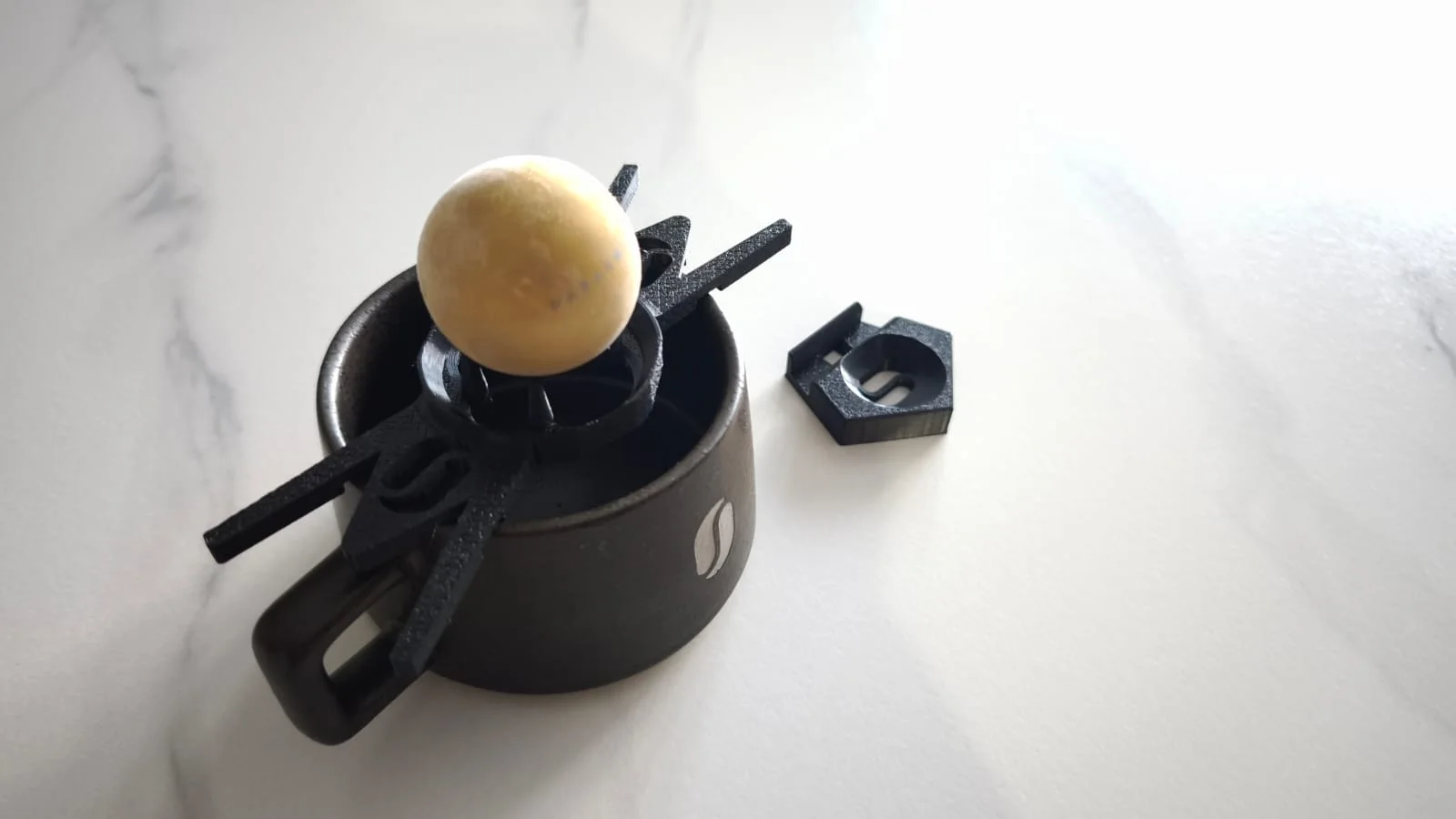 Wide view of the El Injerto cup, 3D-printed interface, Chilling Rock, and a separate logo sample.
